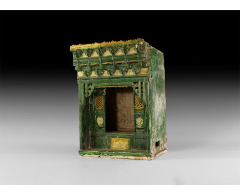 Ming Dynasty, 1368-1644 AD. A green-glazed hollow ceramic niche with detailed canopy, decorative protomes, open central secti