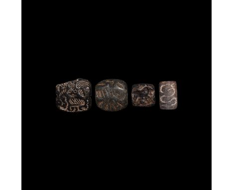 3rd millennium BC. A mixed group of four bifacial stone stamps, comprising: one with curled serpent to one side, standing fig