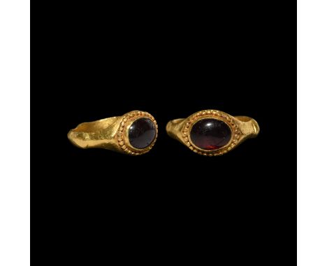 3rd century AD. A gold finger ring with keeled hoop, ellipsoid pads to the outer face, granulated collar to the bezel with in