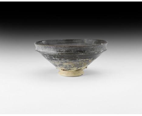 Song Dynasty, 960-1127 AD. A ceramic brown-glazed conical tea bowl with basal ring, and an un-glazed decorative band near the