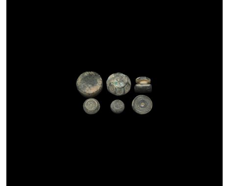 6th-10th century AD. A group of six bronze weights comprising: two tabular; one biconical; one barrel-shaped; one facetted wi