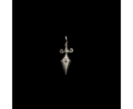 9th-11th century AD. A silver pendant formed as a lozenge-shaped dagger with bevelled edges, scrolled guard, recurved loop tw