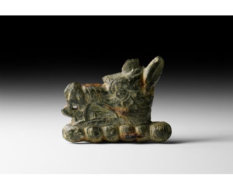18th century AD. A pewter heraldic mount of a boar's head with open mouth revealing tongue and tusks, above a twisted wreath.
