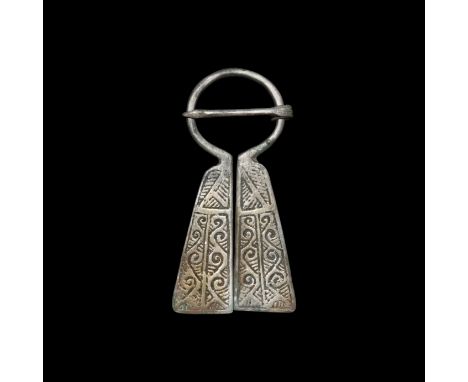12th-14th century AD. A Viking-inspired silver omega penannular brooch, flanges with two panels of mirrored scroll decoration