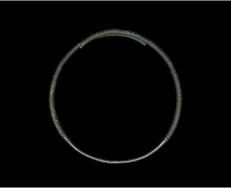 5th-8th century AD. A copper-alloy twisted neck-ring formed as a tapering shank with round-section median section, twisted ba
