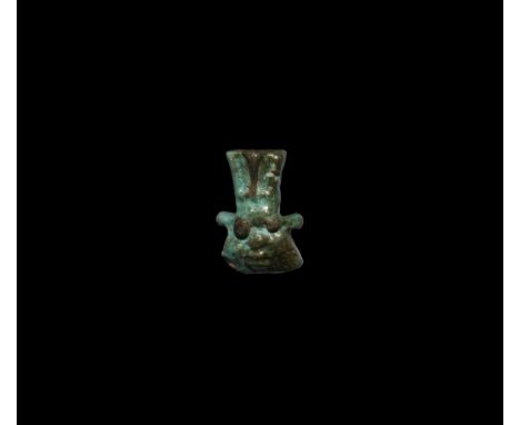 Late Period, 664-332 BC. A glazed composition amuletic mask of Bes with feather headdress, pierced for suspension.   2.67 gra