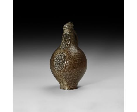 16th century AD. A salt-glazed stoneware jug of bartmannskrug type with bulbous body, narrow base, ribbed collar and strap ha