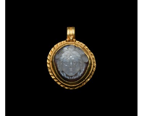2nd-3rd century AD. A gold plaque pendant with crimped flange rim, beaded wire collar to the cell and ribbed loop with granul