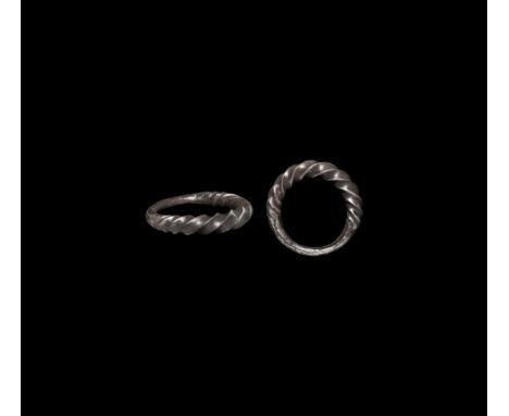 9th-11th century AD. A silver ring with tightly twisted and expanding upper part, the lower part plain.   5.74 grams, 24.33mm