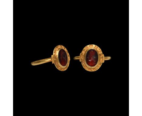 13th-14th century AD. A gold finger ring with plain round-section hoop, disc bezel with central cell and legend to the flange