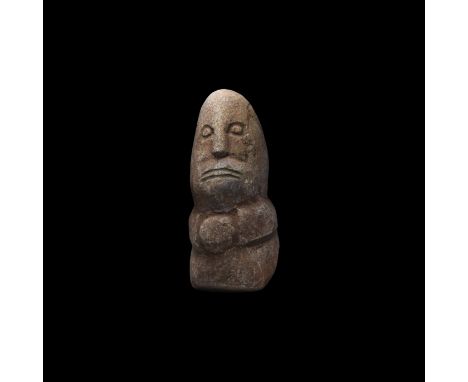 4th century BC. A tall rhyolite idol with conical head and squat body, low-relief facial features, arms forming a horizontal 