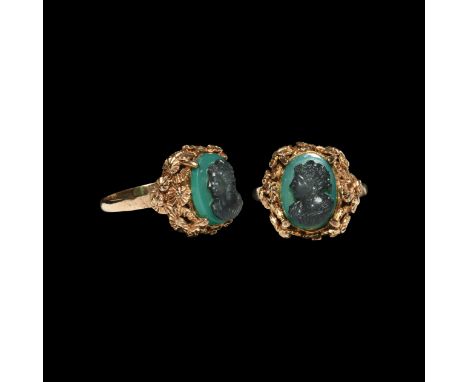 18th century AD. A gold finger ring with hollow-formed bezel of piled rosettes, claw setting for a green glass cloison gemsto