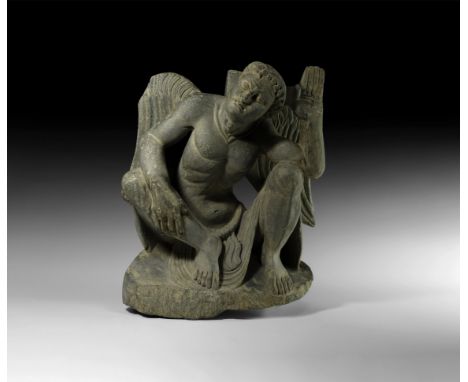 2nd-3rd century AD. A carved schist figure of Atlas crouching with wings spread to the rear, right hand resting on the right 