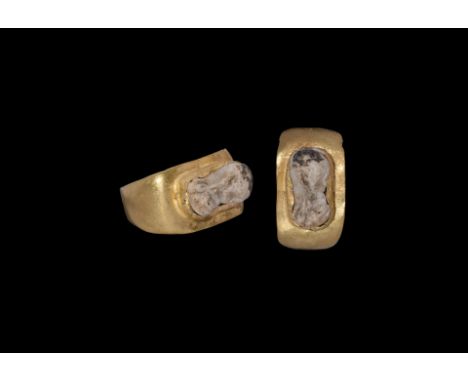 2nd century AD. A gold ring comprising a flat-section hoop and flared shoulders, flat bezel with cell, inset cameo profile fe