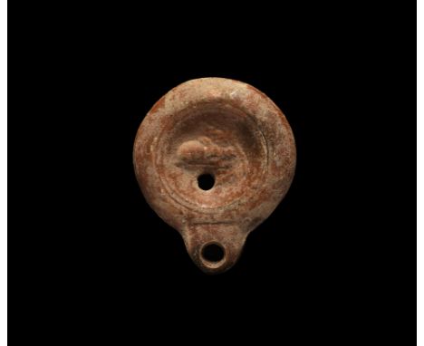 2nd century AD. A small terracotta oil lamp with stub nozzle; the discus with a rabbit on a baseline, a branch to the front. 