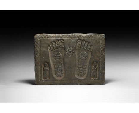 2nd century AD. A carved green schist Buddhapada relief block, rectangular in plan featuring two stylised footprints and two 