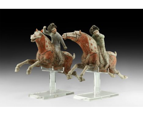 Tang Dynasty, 618-906 AD. A dynamic pair of ceramic polo-player figures, each a galloping horse with legs extended and mane f
