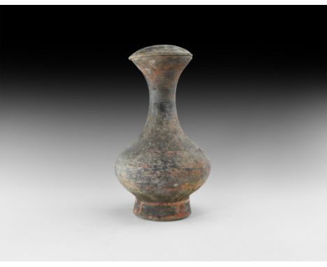 Han Dynasty, 206 BC-220 AD. A ceramic jar of waisted profile with bulbous body and flared base, domed lid. 2.5 kg, 37cm (14 1