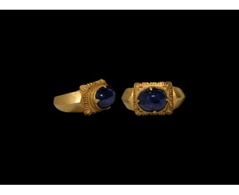 16th century AD. A gold finger ring with keeled hoop, plaque with gadrooned border, claw setting for a sapphire cabochon. 12.