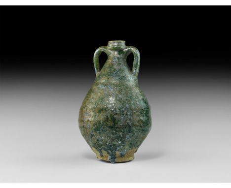 3rd century BC-2nd century AD. A ceramic jar with piriform body, basal ring, balustered mouth and lateral strap handles, appl