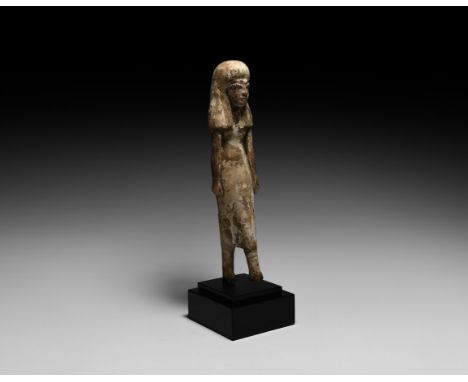 Middle Kingdom, 2050-1652 BC. A carved wooden figure of a striding female, hair to the shoulders, wearing a long tunic-style 