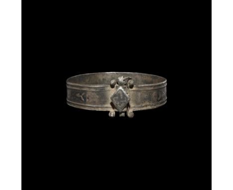 8th-10th century AD. A silver strap bracelet with substantial fastener formed as interlocking loops, cylindrical pins, cotter
