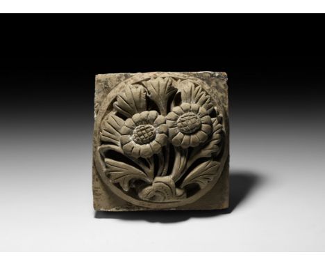 Han Dynasty, 206 BC-220 AD. A square ceramic tile with raised roundel containing three flowers and foliage, traces of pigment
