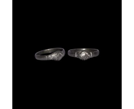17th century AD. A flat-section silver ring with raised clasped hands, fede, motif to the bezel, transverse collar to each si
