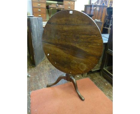 A Georgian oak snap top table, the circular top raised on a turned pillar and tripod