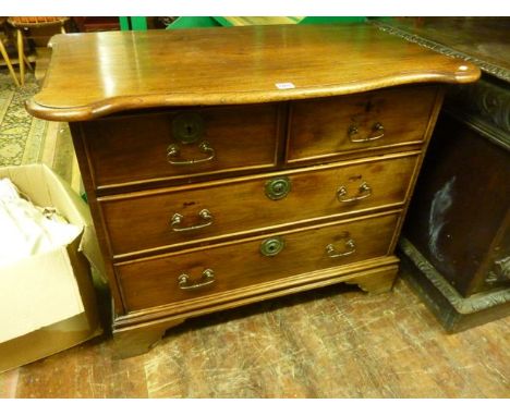 A 19th century teakwood Anglo-Indian chest of two long and two short drawers with pronounced and shaped top, raised on bracke