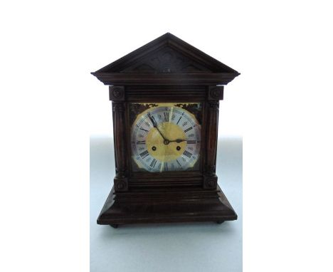 A late 19th century bracket clock enclosing a square brass dial with silvered chapter ring, the casework with split spindle m