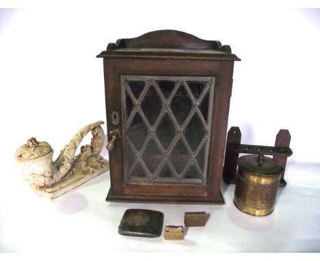 A stained oak smoker's cabinet, the glazed panelled door with leaded detail revealing a divided interior over two drawers con