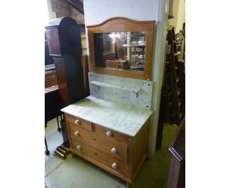 A stripped pine washstand fitted with two long and two short drawers beneath a grey and white flecked marble top and raised s