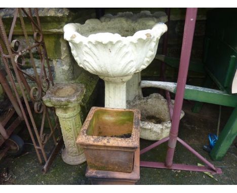 A pair of weathered cast composition stone two sectional garden planters with circular foliate bowls raised on fluted columns