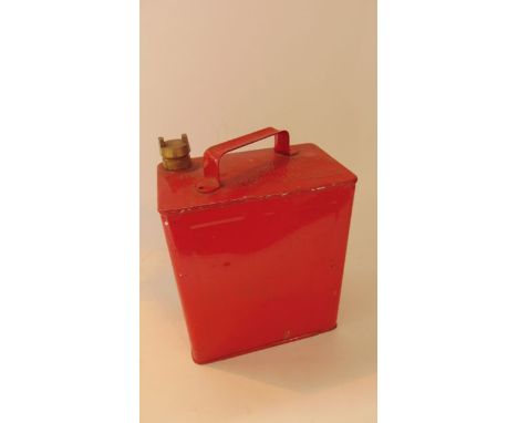 A vintage fuel can with all over red painted finish and impressed text reading Petroleum Spirit Highly Flammable with brass s