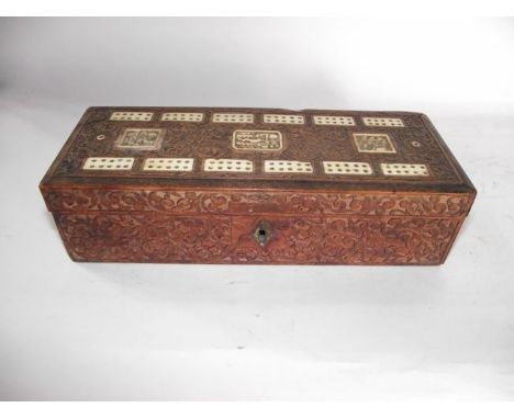 A 19th century eastern cribbage/games box with all over intricately carved shallow and floral detail, the top set with pierce