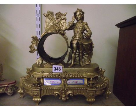 A 19th century gilt spelter mantle clock, the movement enclosed within a drum shaped case with military motifs, the case with