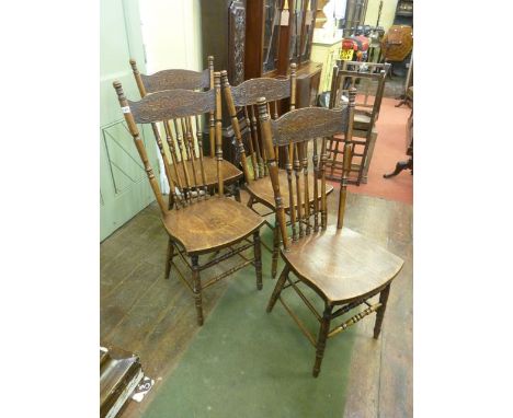 A set of four late 19th century American comb back dining chairs with press moulded detail and solid seats, on turned support