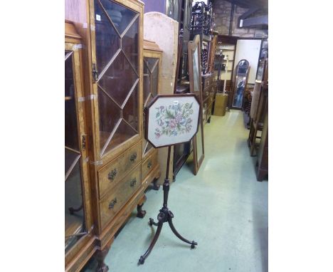 A 19th century mahogany pole screen with adjustable rise and fall panel raised on swept tripod cornocopia style supports