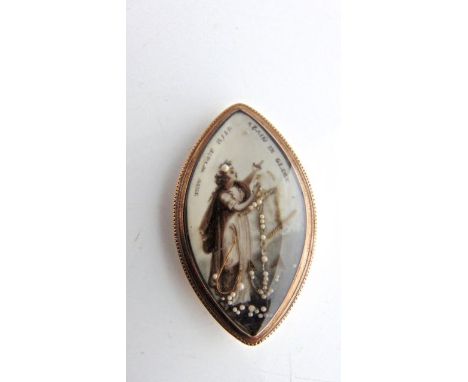 A Georgian/Regency mourning pendant/brooch, the navette-shaped body inset with an ivory plaque, painted with a woman pointing