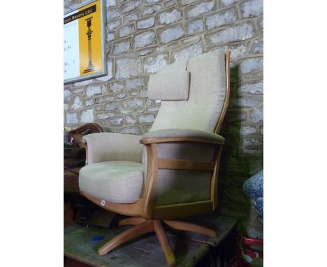 A contemporary Ercol "Gina" swivel lounge chair with oatmeal coloured upholstered seat, back and arms within a light elm show