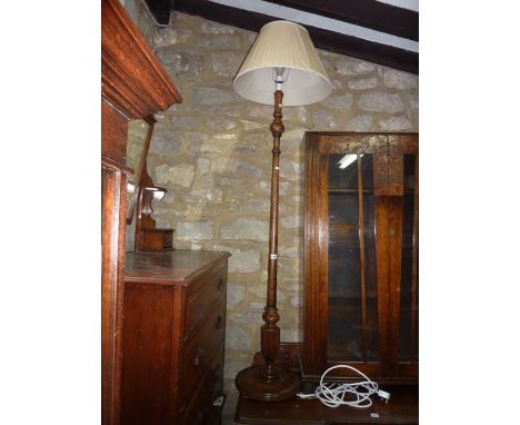 An oak standard lamp, the turned column with partially fluted detail raised on a circular moulded disc shaped platform and tu