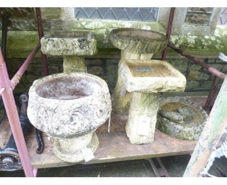 Four weathered bird baths of varying design together with a further weathered cast composition stone garden planter of circul