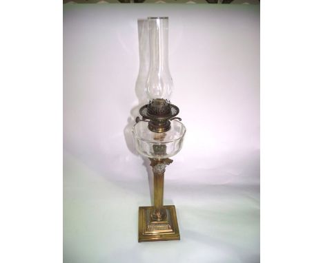 A good quality Victorian brass oil burning lamp raised on a Corinthian column stand, set before a clear cut glass fount with 