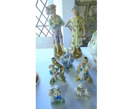 A pair of late 19th century continental figures of a bare foot boy and girl, she holding a ewer, both raised on hollow cast b