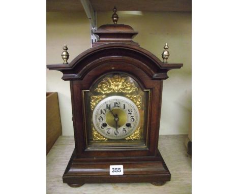 An Edwardian bracket clock in a polished walnut case with arched brass dial and eight day striking movement