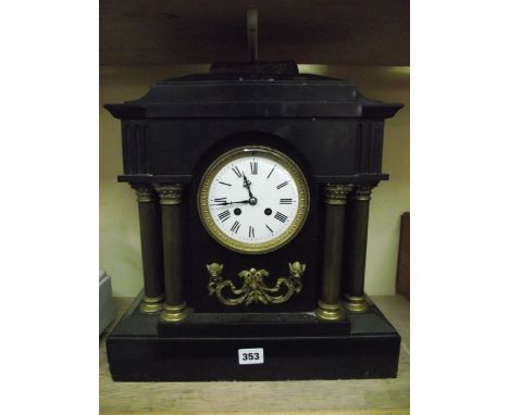 A Victorian black slate mantle clock with polished brass columns and eight day striking movement