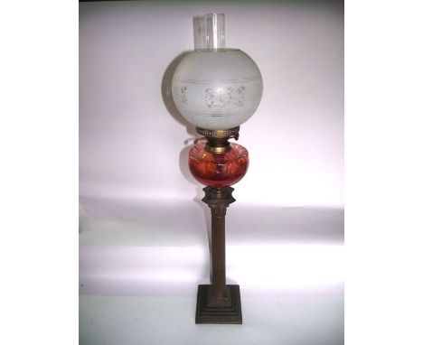 A Victorian oil burning lamp with brass base in the form of a fluted Corinthian column, raised on a squared stepped base supp