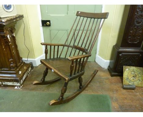 A rustic Windsor comb back rocking chair in ashwood raised on turned supports