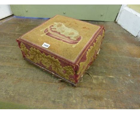 An early Victorian upholstered footstool of square cut form, the original hand worked tapestry showing a recumbent spaniel up